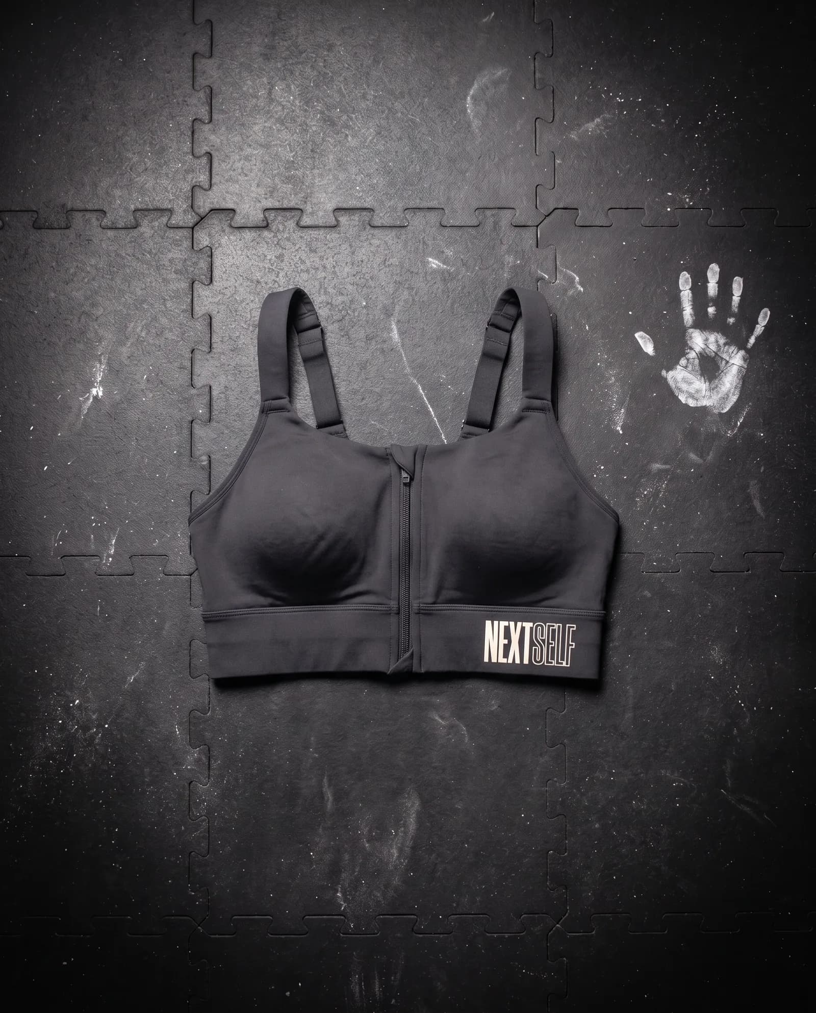 Contour Bra in Carbon, laid flat on a gym floor