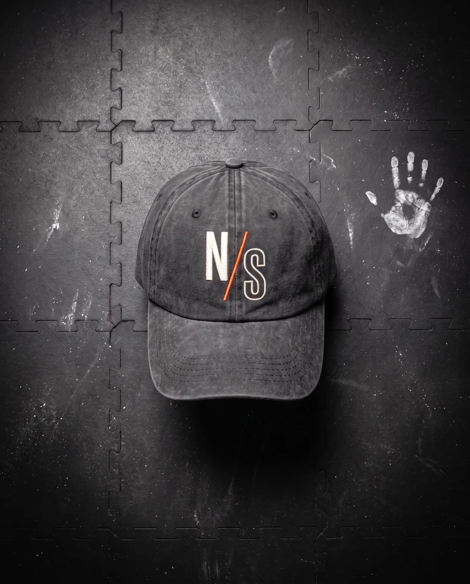 Daily Cap in Carbon, laid flat on a gym floor