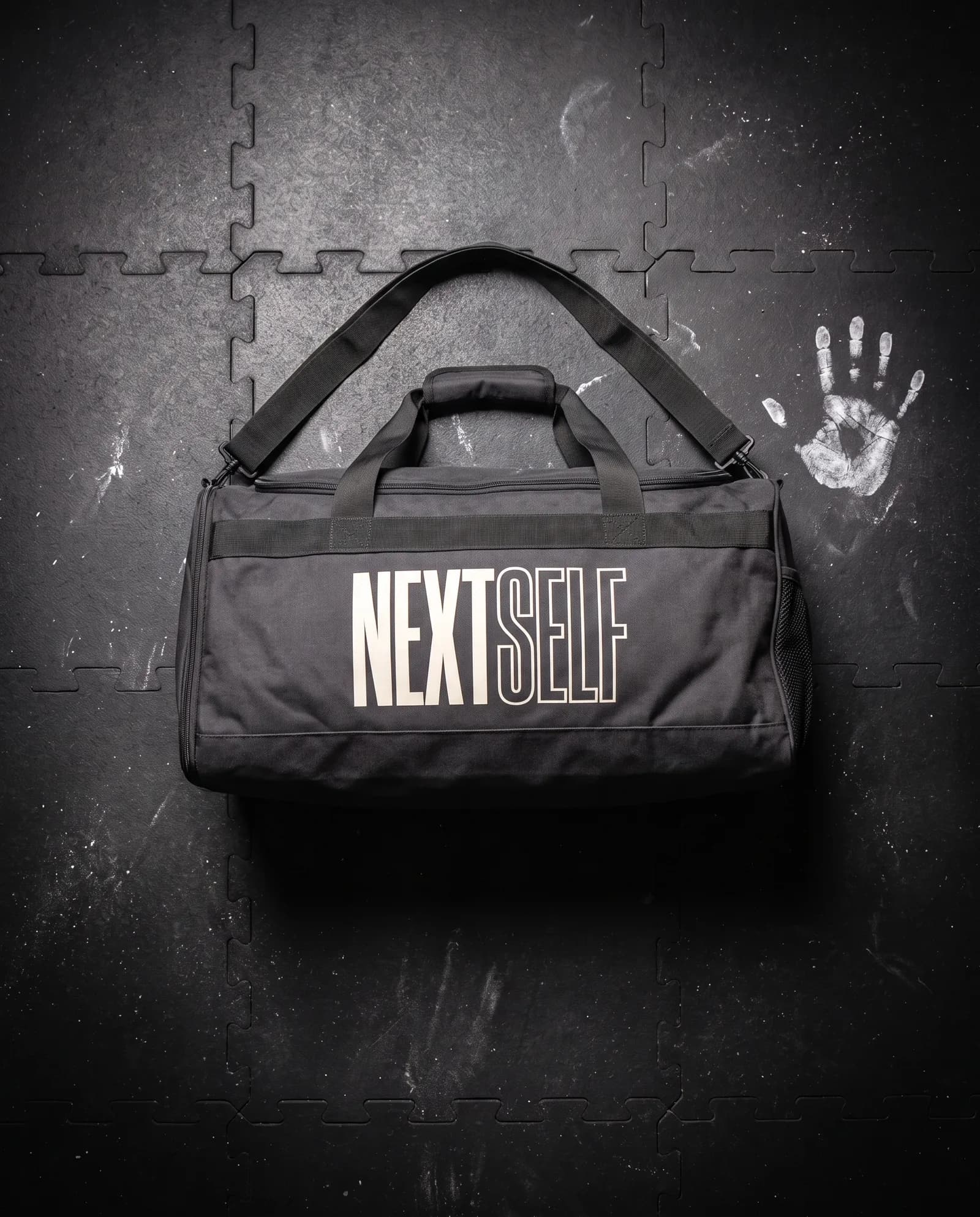 Gym Duffel 40L in Carbon, laid flat on a gym floor