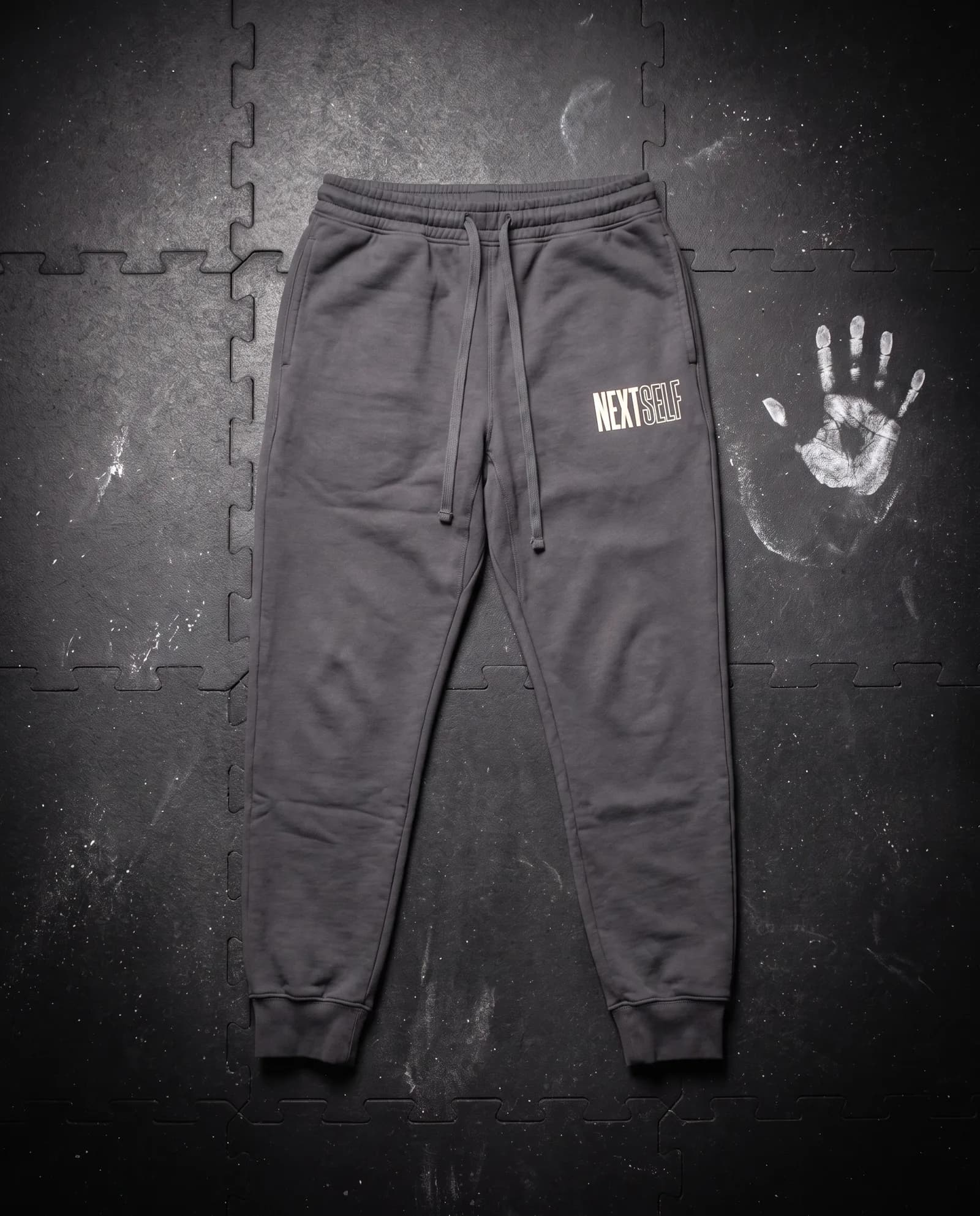 Next Rep Jogger in Carbon, laid flat on a gym floor