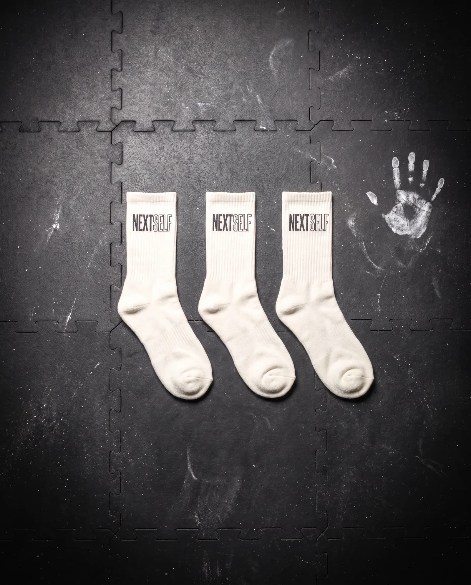 Training Sock 3-Pack in Chalk, laid flat on a gym floor